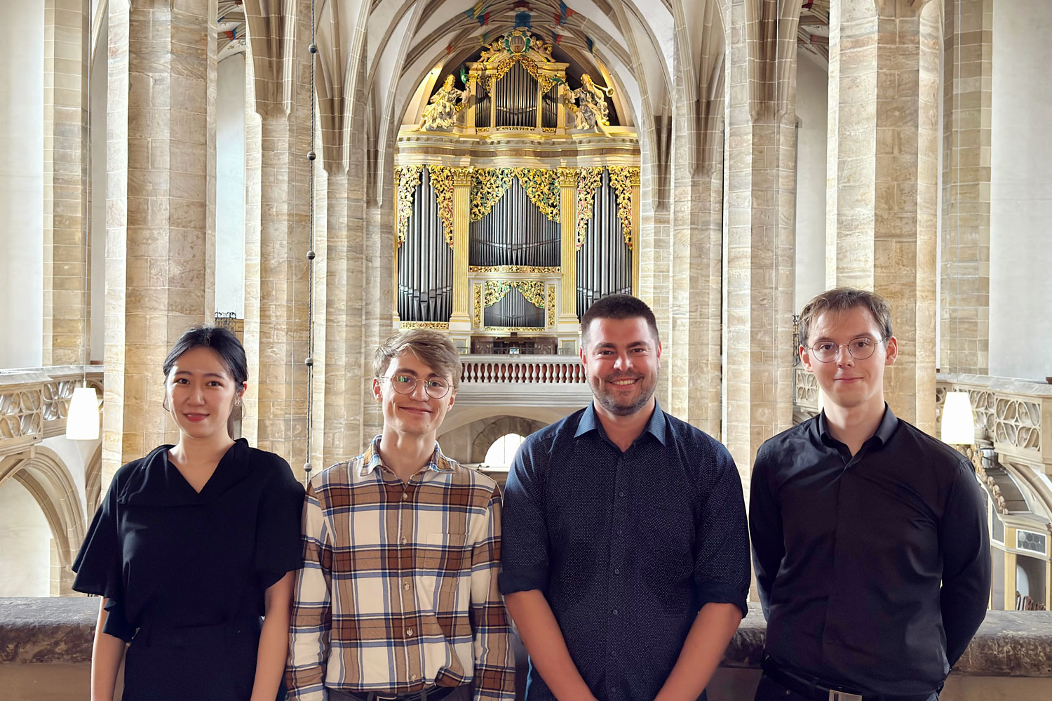 Die Preisträger Hanna Cho, Jannik Gerdes, David Kiefer, Jakub Moneta stehen auf einer Empore – im Hintergrund ist eine Orgel zu sehen