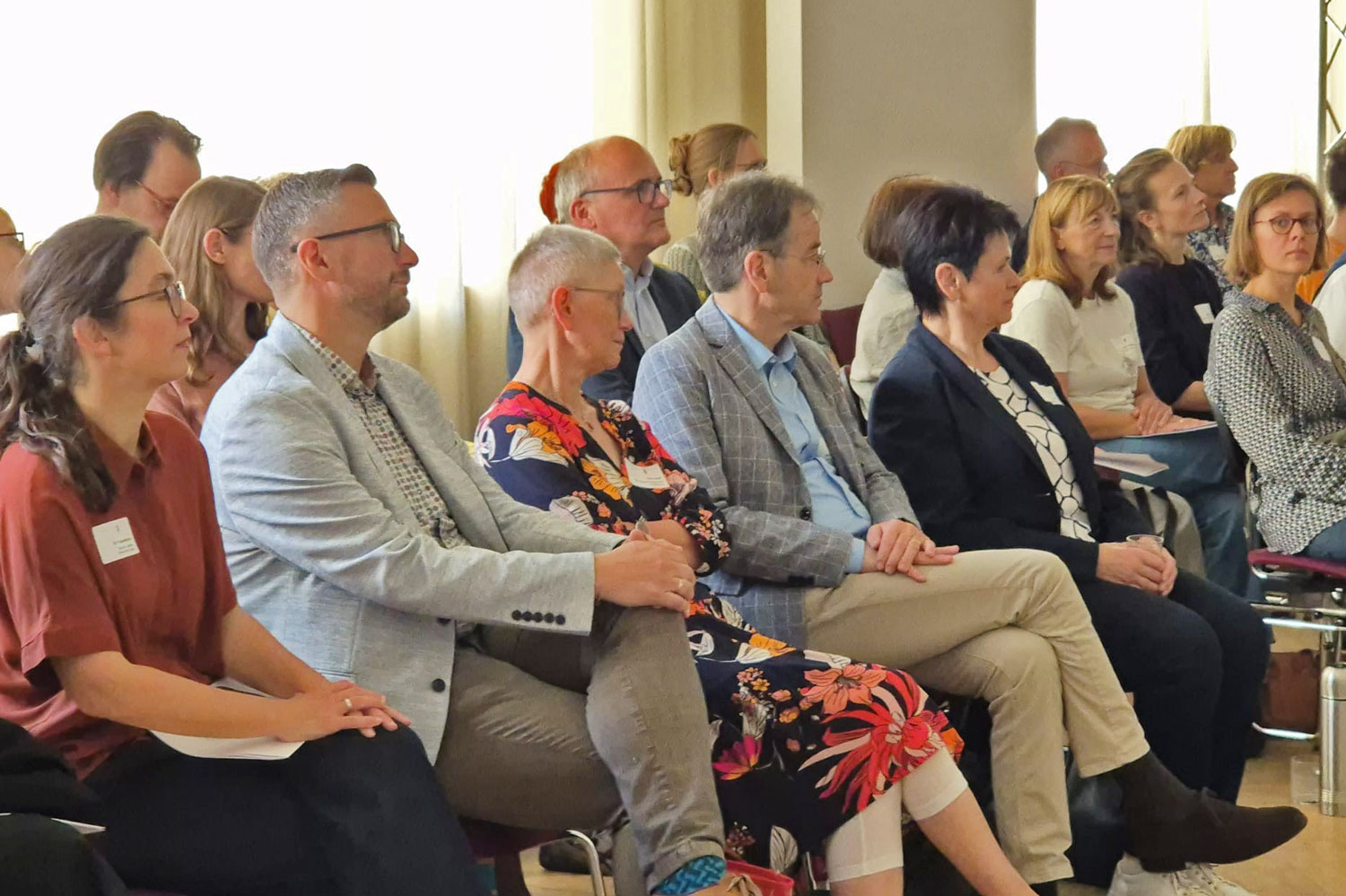 Eindruck vom Fachtag in Leipzig: Rechts steht referierend Prof. Milko Kersten. Ihm gegenüber ist auf der linken Bildeite ein Teil des aufmerksamen zuhörenden Publikums zu sehen.