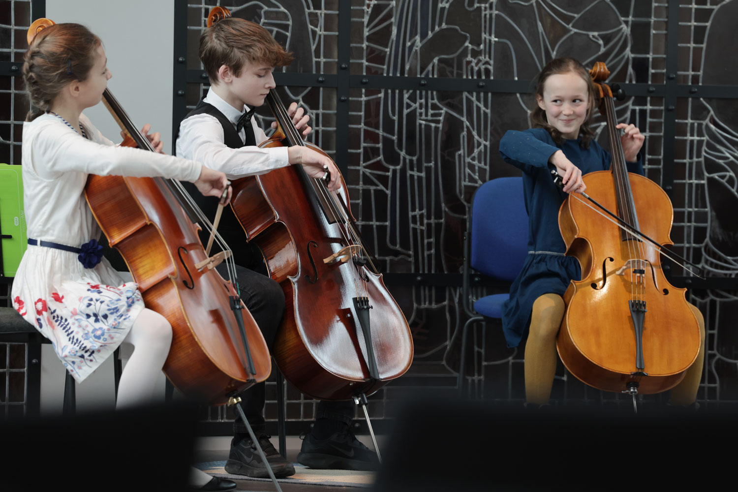 Drei junge Cellistinnen sitzen mit sichtbar viel Freude musizierend bei einem Jugend-musiziert-Vorspiel im Rathaussaal in Zwickau