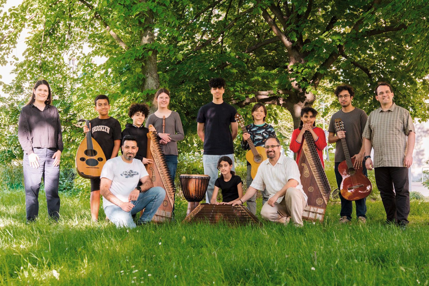 Gruppenfoto eines kleinen Jugendensembles mit Instrumenten im Grünen