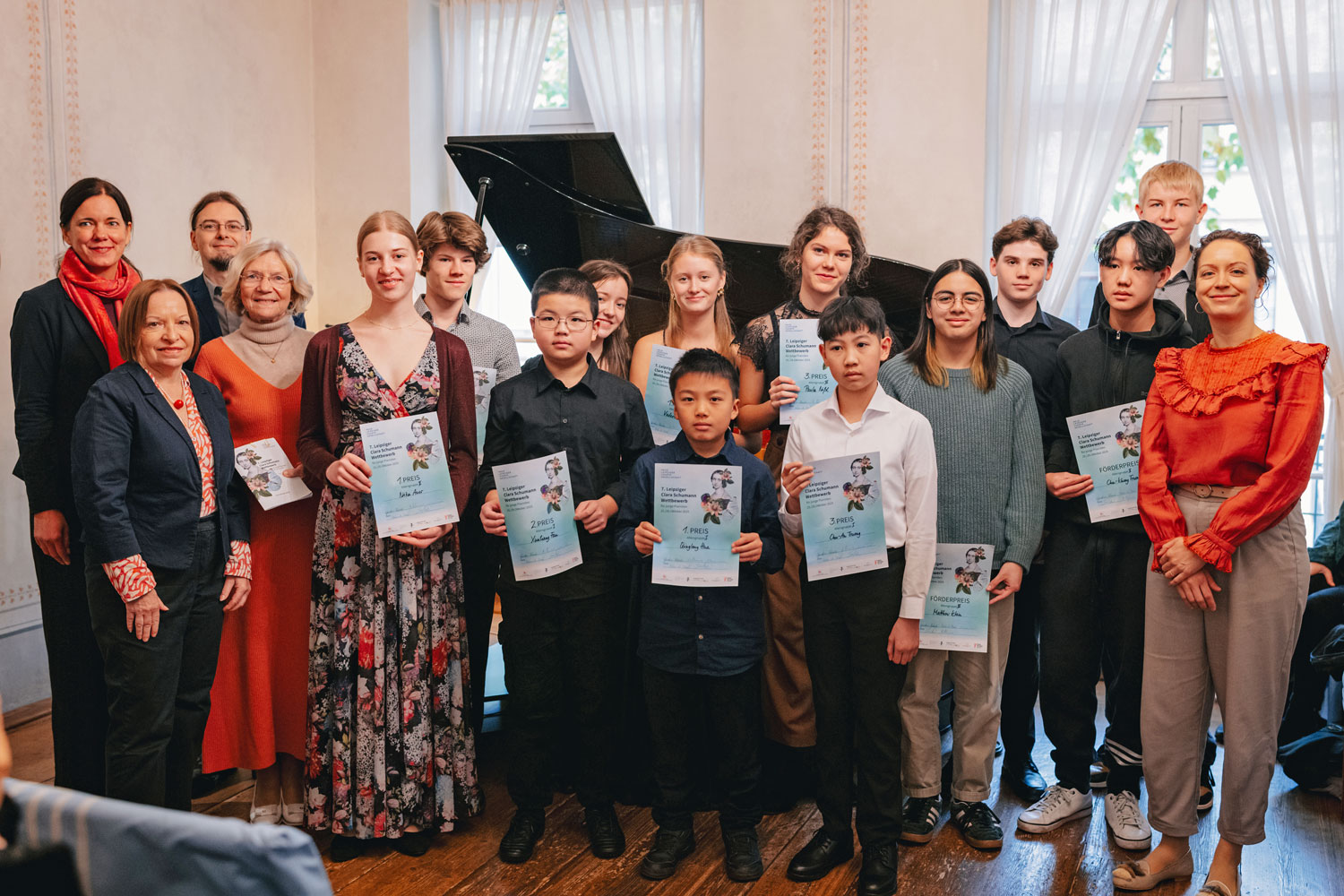 Gruppenfoto vor geäöffnetem Flügel – die jugend Preisträgerinnen und Preisträger halten ihre Urkunden in der Hand